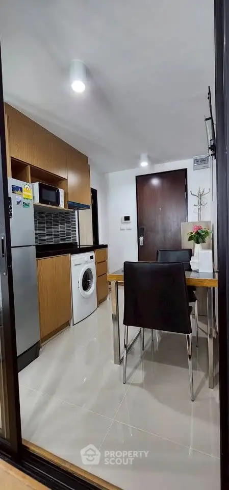 Modern kitchen with sleek appliances and dining area in a stylish apartment.