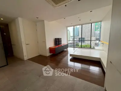 Spacious modern living room with city view and stylish wooden flooring.