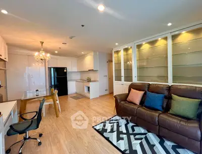 Spacious open-plan living room with modern kitchen and elegant chandelier