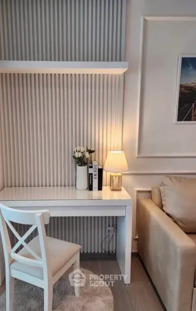 Chic modern living room corner with elegant white desk, cozy chair, and ambient lighting.