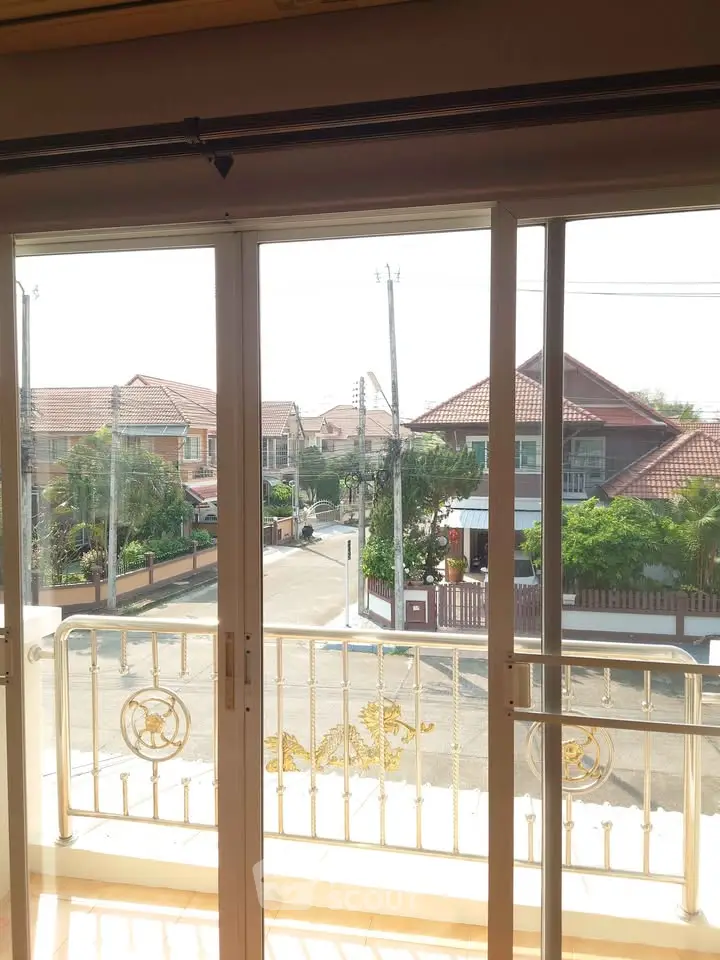 Charming residential view from a balcony with sliding glass doors, showcasing a serene neighborhood.