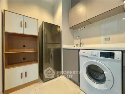 Modern kitchen with washing machine and fridge in compact layout