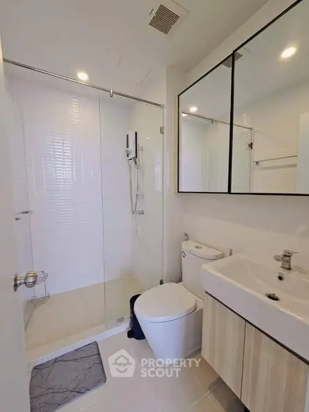 Modern bathroom with glass shower and sleek fixtures in a contemporary home.