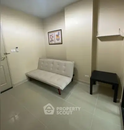 Cozy small living room with modern sofa and wall art, perfect for minimalist living.