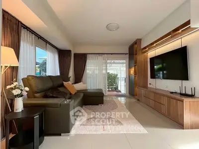 Spacious living room with modern decor and large windows opening to a balcony, perfect for relaxation.
