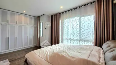 Spacious bedroom with elegant curtains and ample closet space in modern apartment.