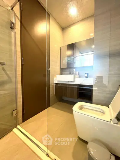 Modern bathroom with glass shower and sleek fixtures in a contemporary apartment.