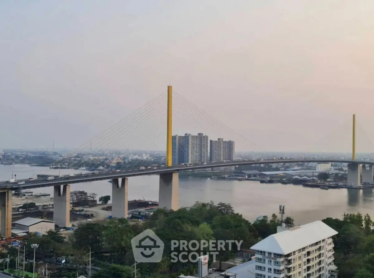 Stunning riverfront view with modern bridge and high-rise buildings at sunset.