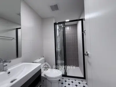 Modern bathroom with sleek design, featuring a glass shower enclosure and stylish fixtures.