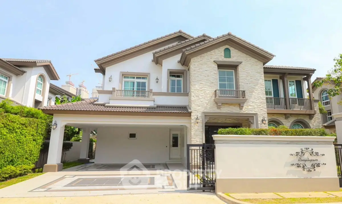 Luxurious two-story house with elegant stone facade and spacious driveway in a serene neighborhood.