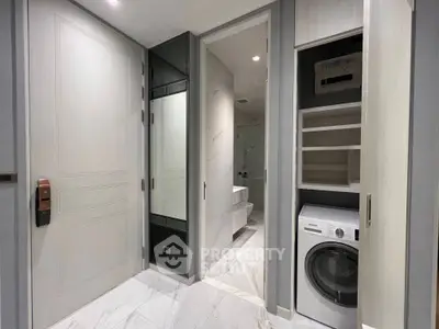 Modern bathroom with sleek design and integrated laundry area featuring a washing machine.