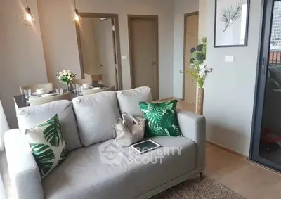 Modern living room with stylish decor and natural light, featuring a cozy sofa and elegant dining area.