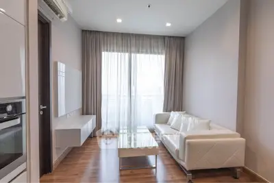 Modern living room with sleek white sofa and floor-to-ceiling windows in a stylish apartment.