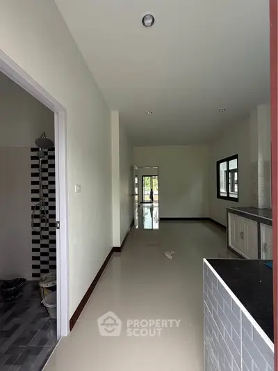 Spacious interior with modern kitchen and bathroom, featuring sleek tiles and ample natural light.