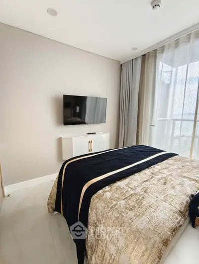 Modern bedroom with stylish decor and wall-mounted TV, featuring large windows for natural light.