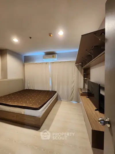 Cozy bedroom with built-in wooden storage units and a large bed, complemented by soft lighting and air conditioning for comfort.
