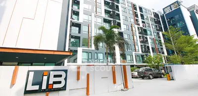 Modern apartment building exterior with contemporary design and lush greenery.