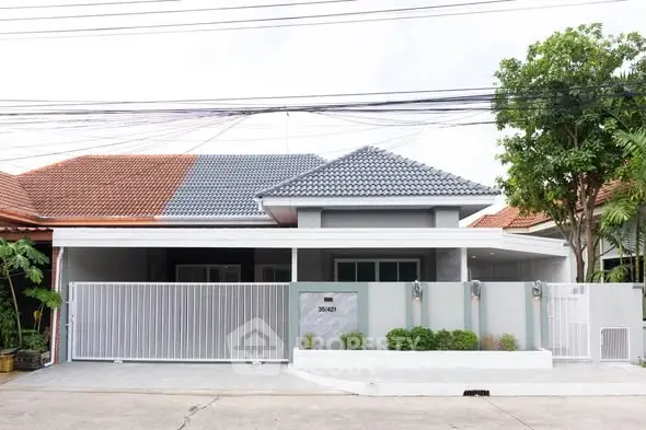 Modern single-story house with gated entrance and contemporary design.