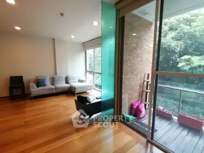 Spacious living room with wooden flooring and balcony view in modern apartment