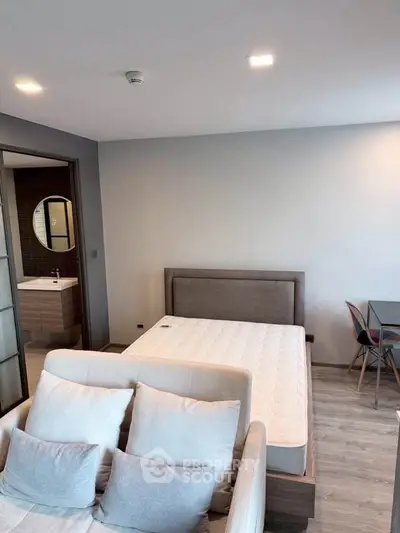Modern bedroom with stylish decor and cozy seating area, perfect for relaxation and comfort.
