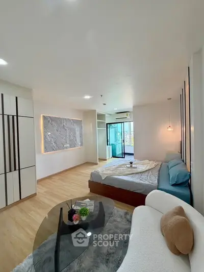 Spacious modern bedroom with stylish decor and balcony access in a luxury apartment.