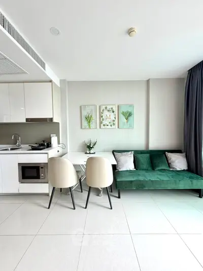 Modern open-layout kitchen and living area with stylish decor and green sofa