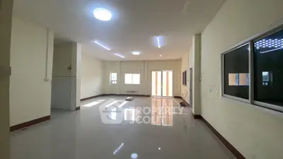 Spacious empty room with large windows and tiled flooring, perfect for customization.