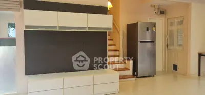 Spacious living area with modern storage and sleek refrigerator