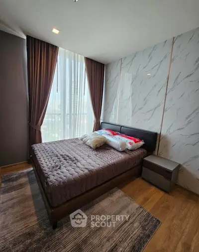 Modern bedroom with large windows and stylish decor in a high-rise apartment.
