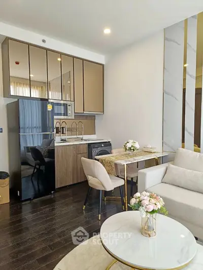 Elegant open-plan living space with modern kitchen, sleek cabinetry, and cozy dining area, complemented by stylish furnishings and natural light.