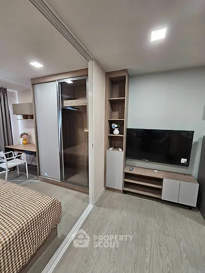 Modern bedroom with sliding wardrobe and TV unit in stylish apartment