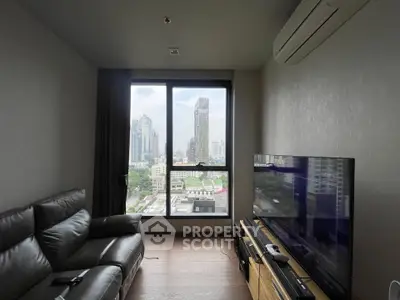 Modern living room with city view, featuring sleek furniture and large window.