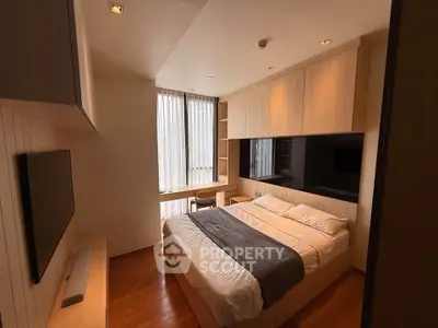 Modern bedroom with built-in storage and large window for natural light.