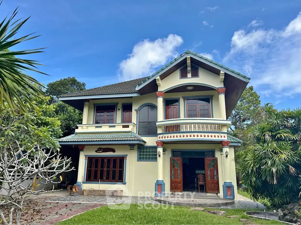 Charming two-story house with lush garden and traditional architectural design.