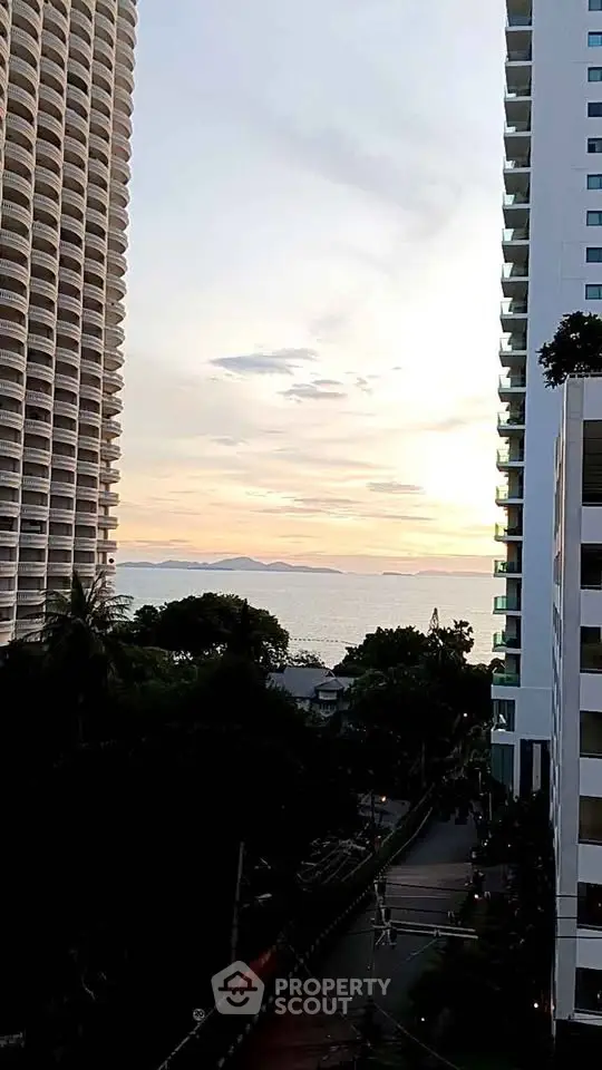Stunning ocean view between modern high-rise buildings at sunset.