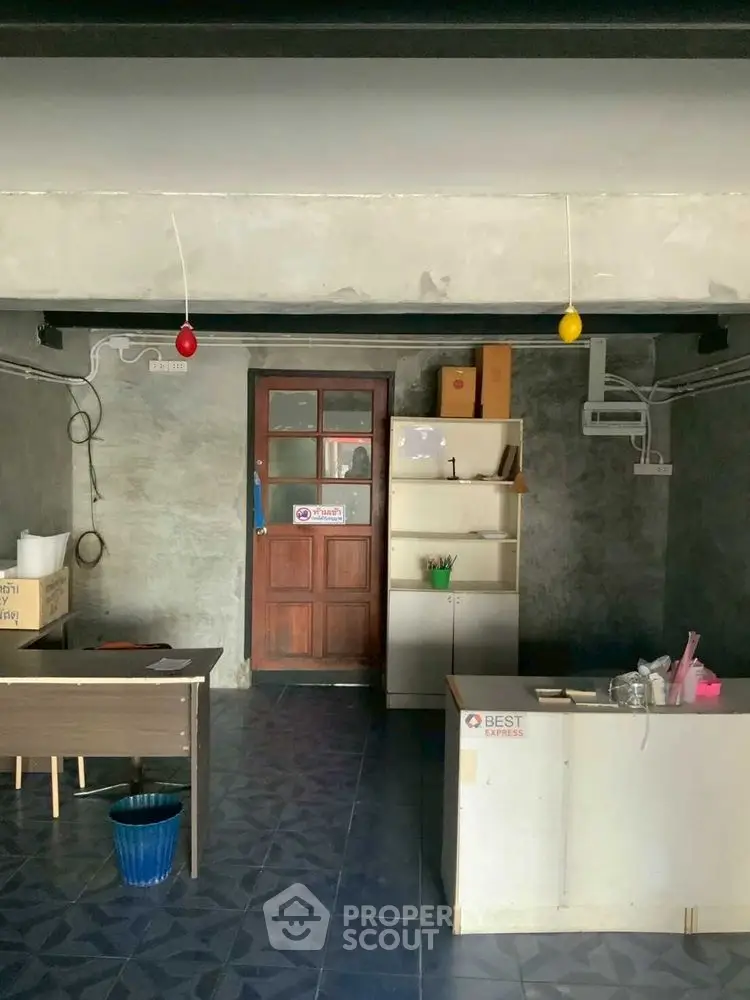 Industrial-style room with concrete walls and minimal furnishings, ideal for creative workspace.