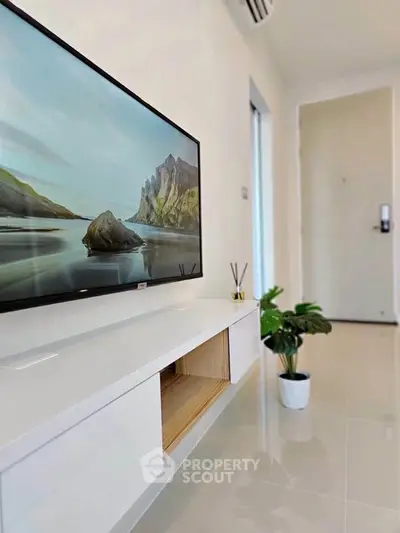 Modern living room with sleek TV and stylish decor in a bright, airy apartment.