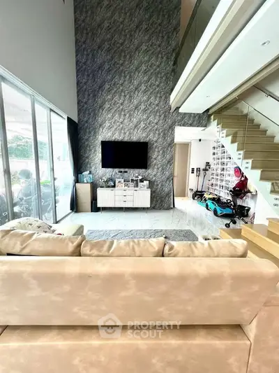 Luxurious living room with high ceiling and modern staircase