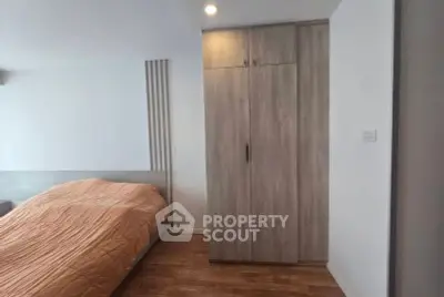 Modern bedroom with wooden flooring and sleek wardrobe design.