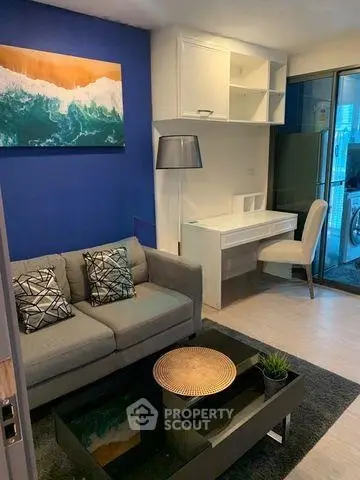 Modern living room with stylish decor and balcony view, featuring a cozy sofa and sleek furniture.