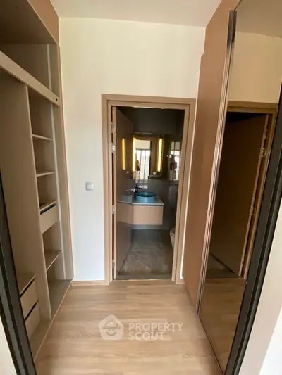 Modern interior with sleek bathroom and built-in storage, featuring elegant lighting and contemporary design.
