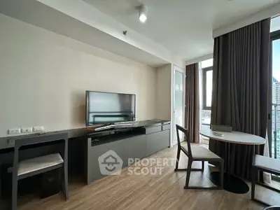 Modern living room with sleek furniture and large window offering city views.