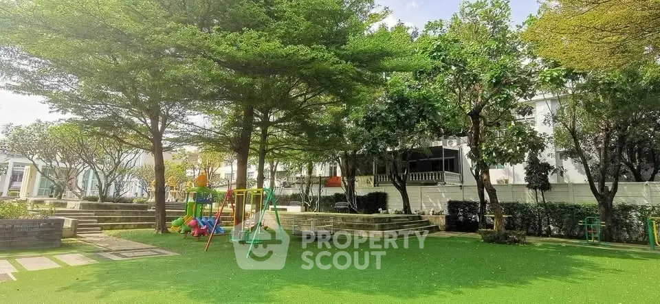 Charming residential garden with lush greenery and playground, perfect for family living.