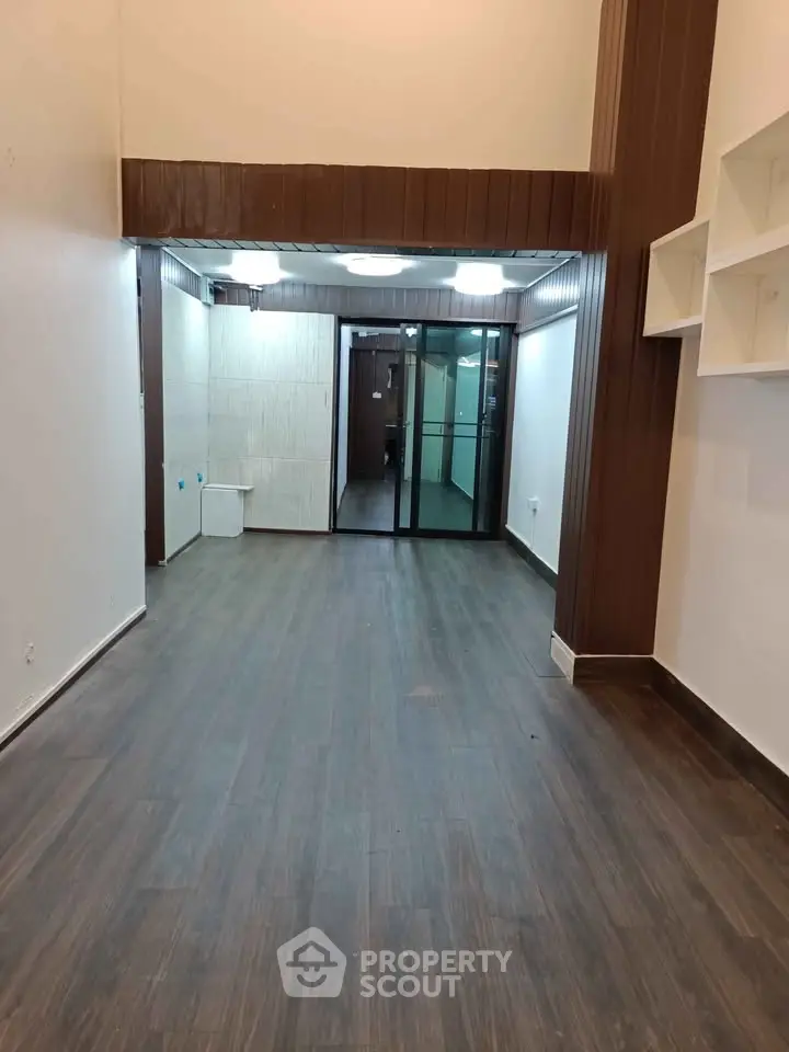 Spacious interior with wooden flooring and modern lighting, ideal for versatile living or office space.