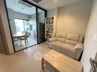 Modern living room with cozy sofa and open kitchen layout in stylish apartment.