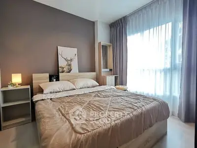 Cozy bedroom with modern decor and large window for natural light.