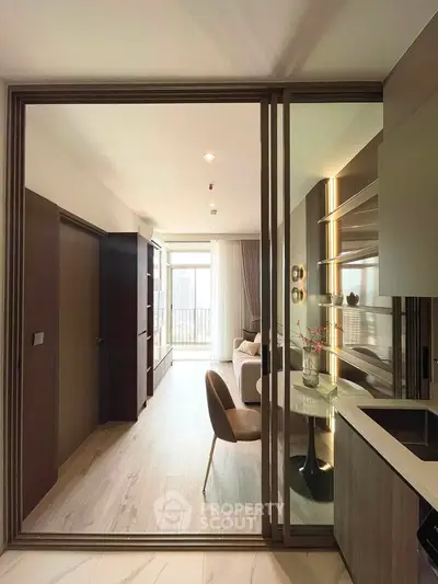 Modern living room with elegant decor and open layout, featuring a cozy seating area and stylish shelving.