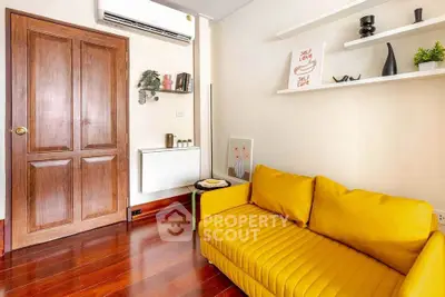 Charming living room with vibrant yellow sofa and wooden accents, perfect for cozy relaxation.