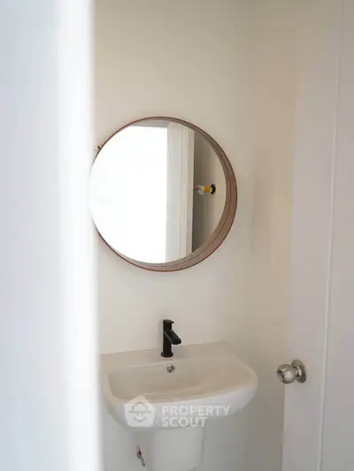 Minimalist bathroom with round mirror and sleek sink design