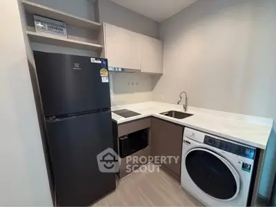 Modern kitchen with sleek appliances and ample storage in a compact layout.